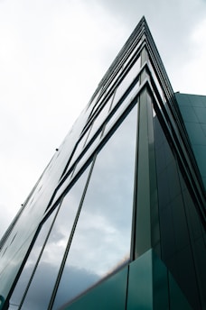 a tall glass building with a sky background