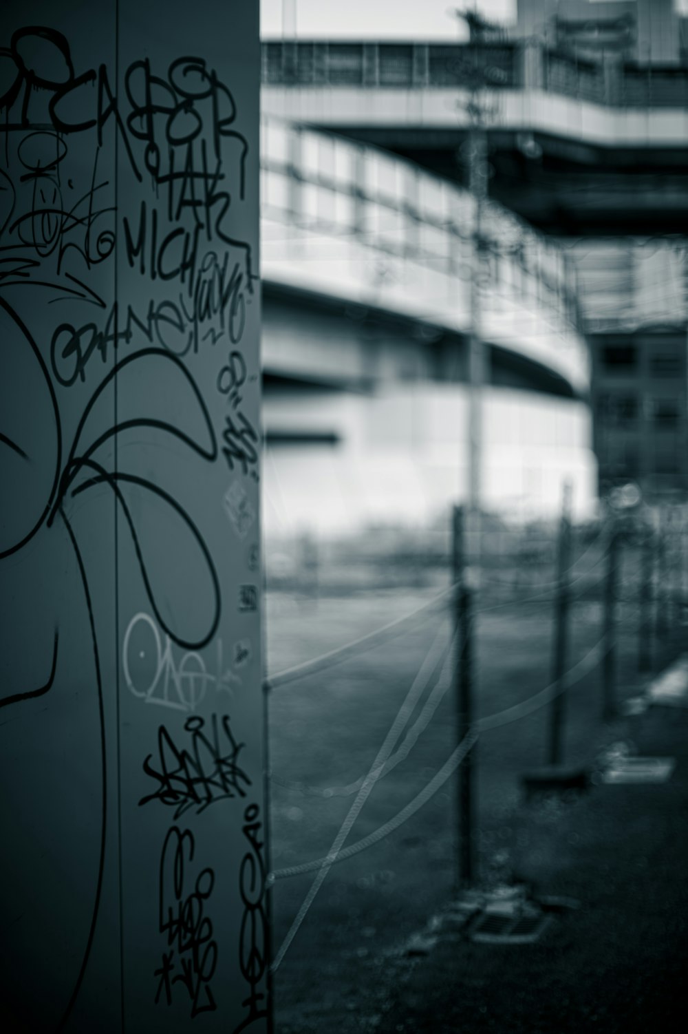 a black and white photo of graffiti on a pole