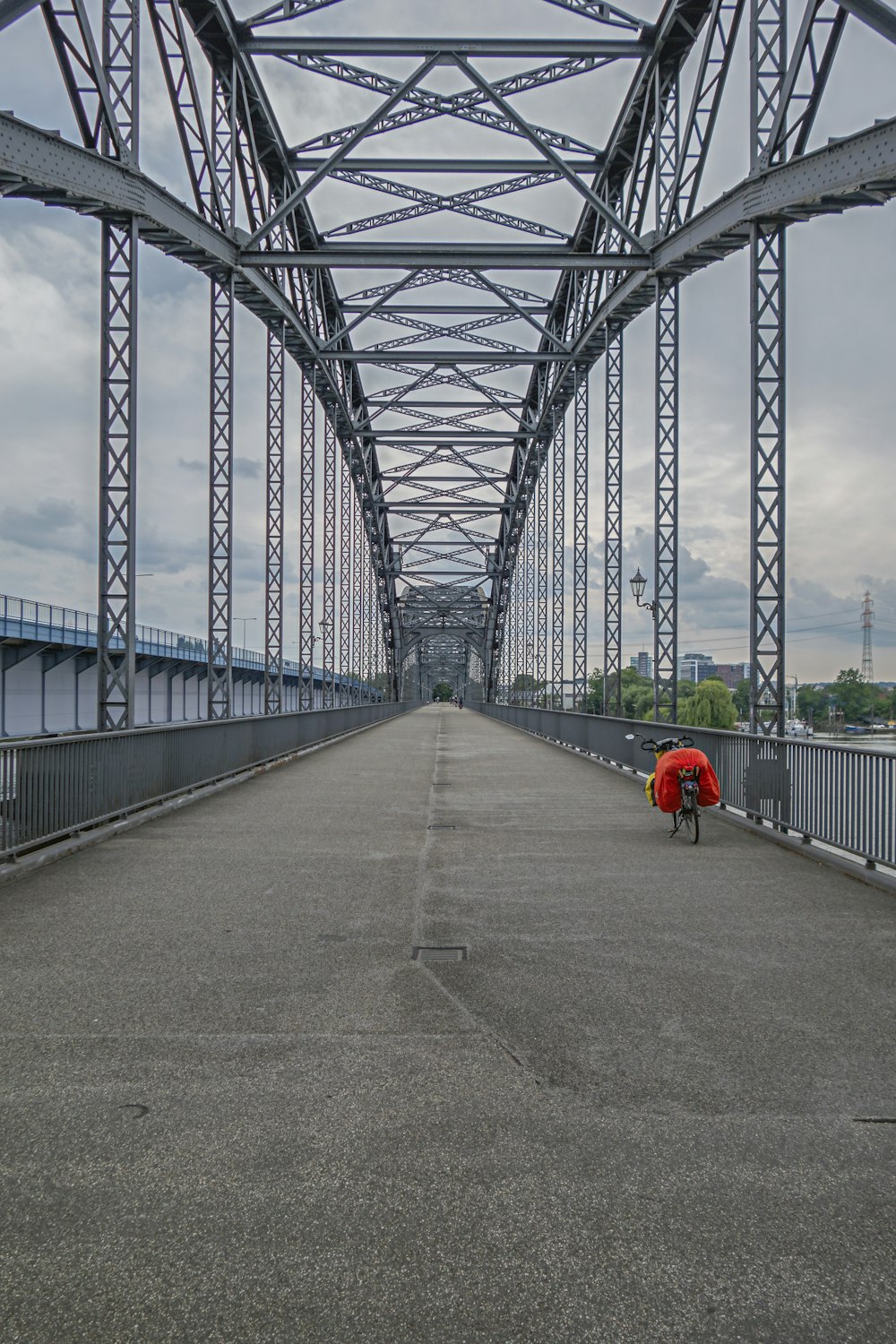 a man with a red backpack walking across a bridge