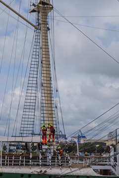 Crew members inspecting a ship's deck with safety gear.