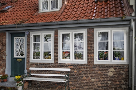 a brick building with a white bench in front of it