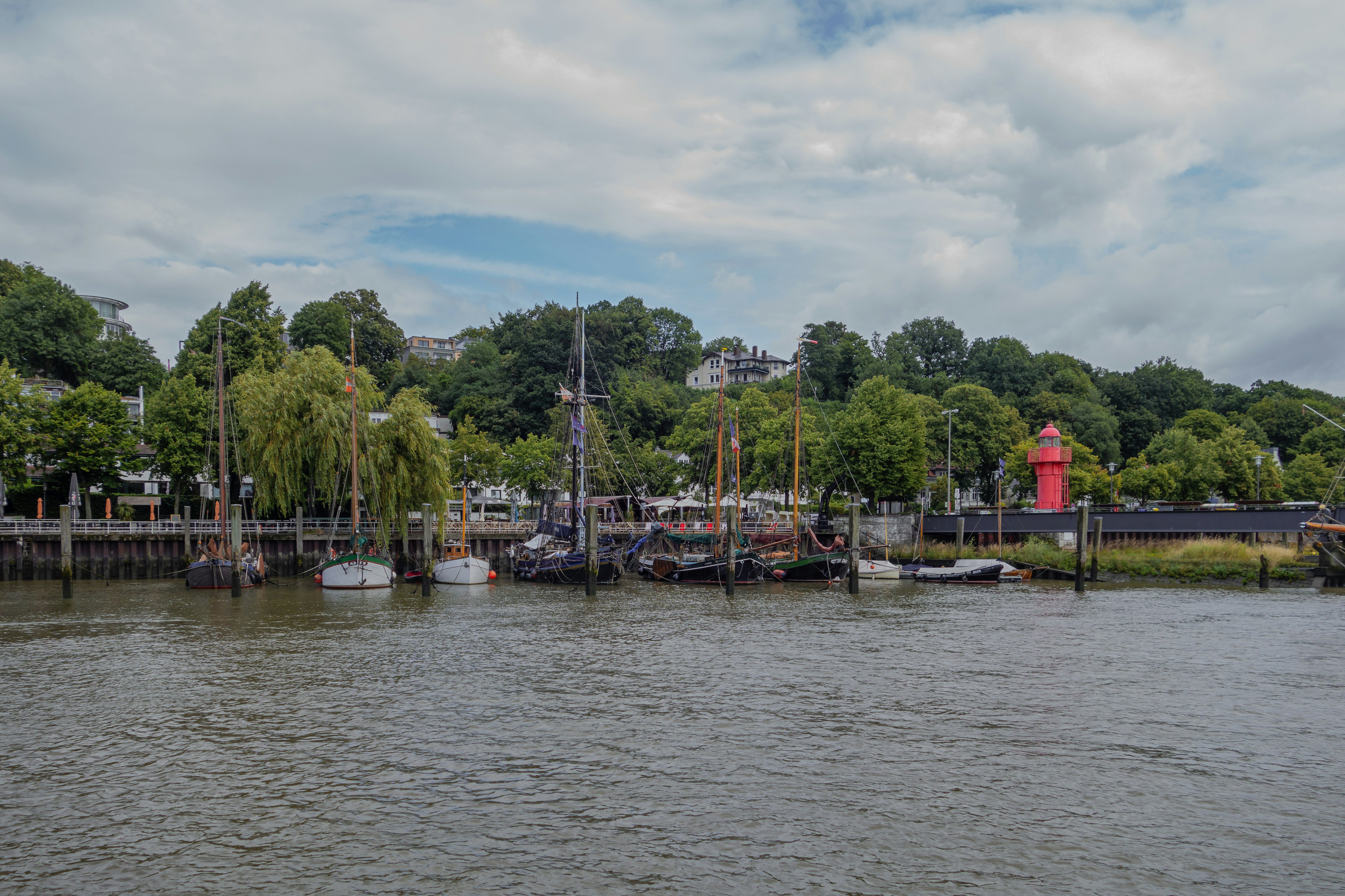 a body of water with boats and trees in the background, 