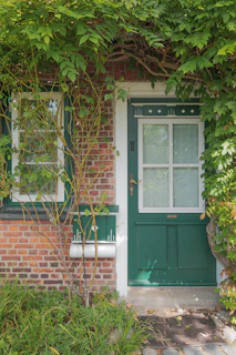 The inviting entrance of the house with a vintage lantern and climbing ivy.