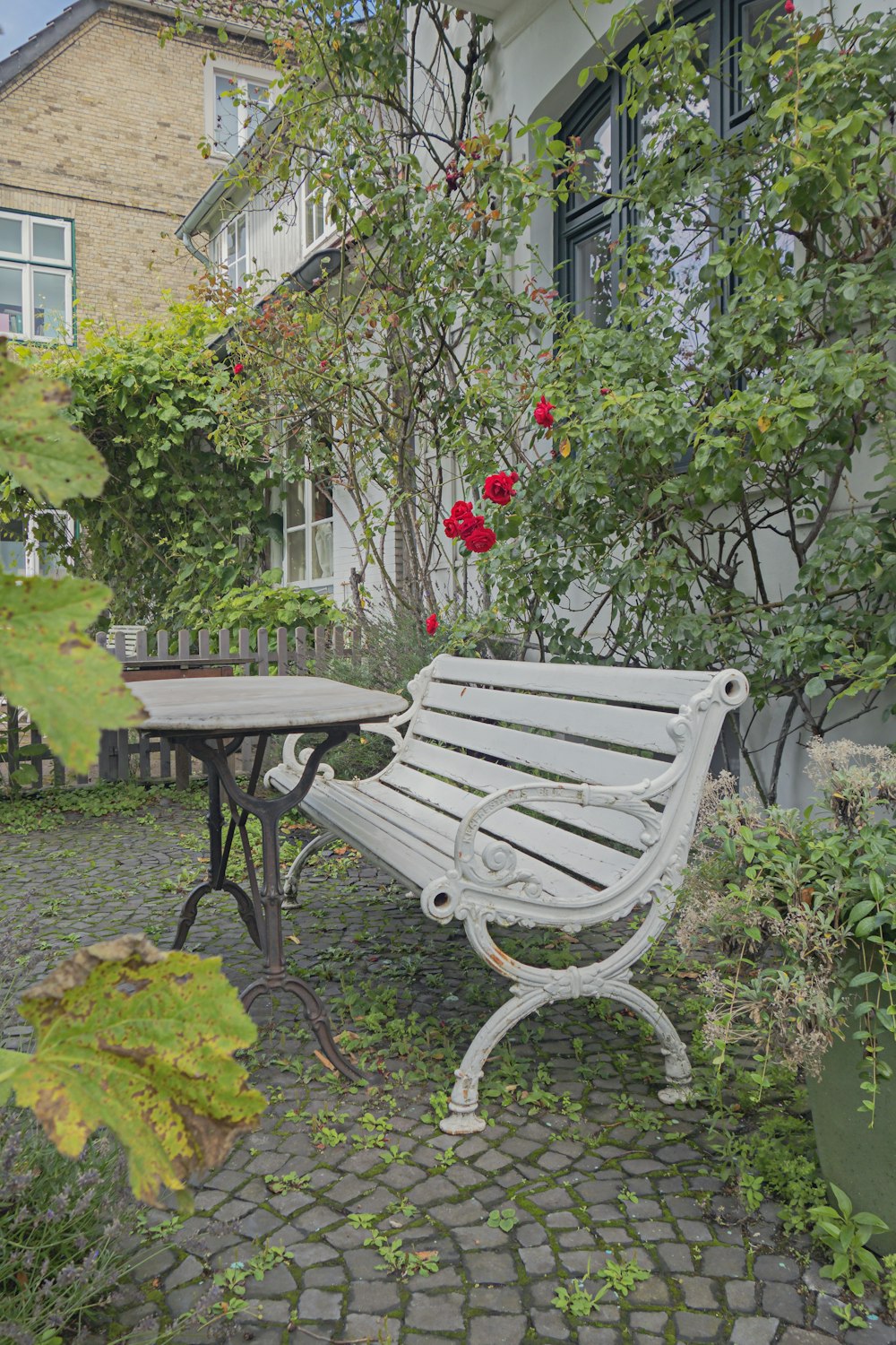 a white bench sitting next to a small table