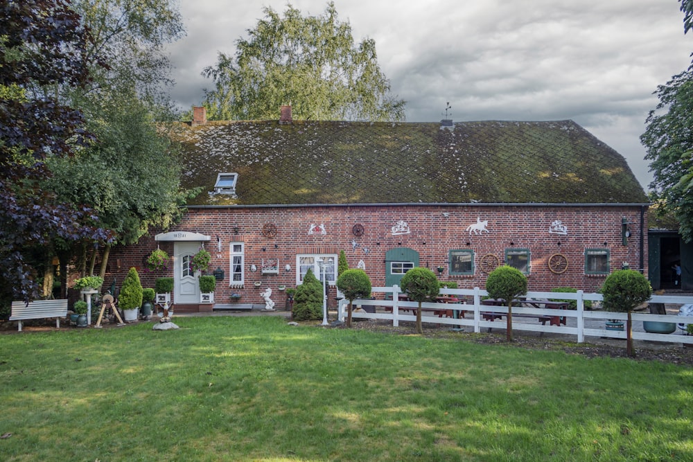 a red brick house with a white picket fence