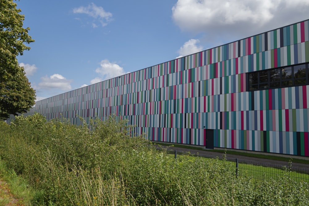 a multicolored building next to a grassy field