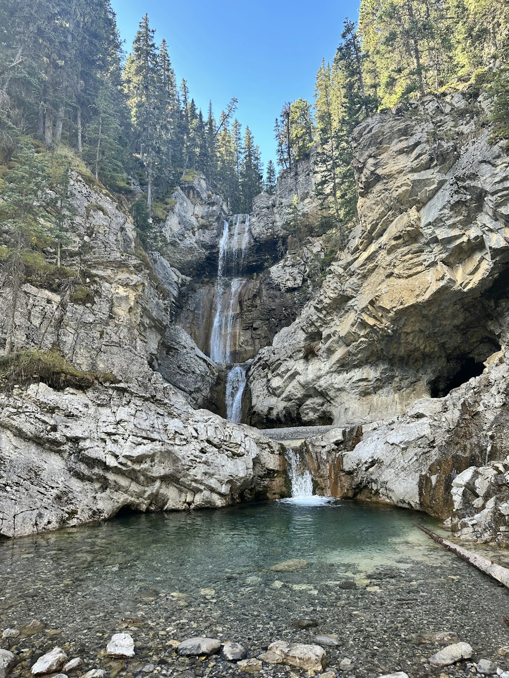 a small waterfall in the middle of a mountain