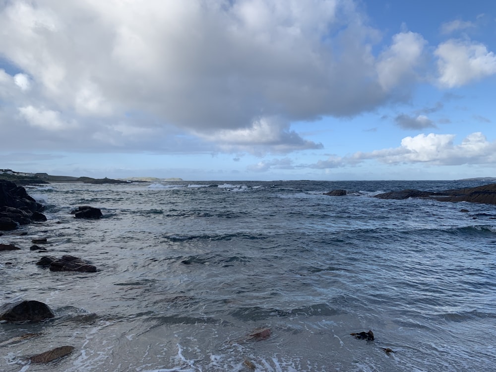 a body of water with rocks in the foreground