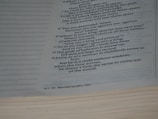 A close-up of a page from a book, featuring text in a columned format. The text includes numbered lines and is presented in a poetic or biblical style, with some words highlighted in bold.