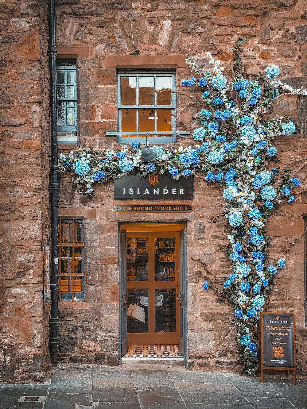 a stone building with a cross made of flowers