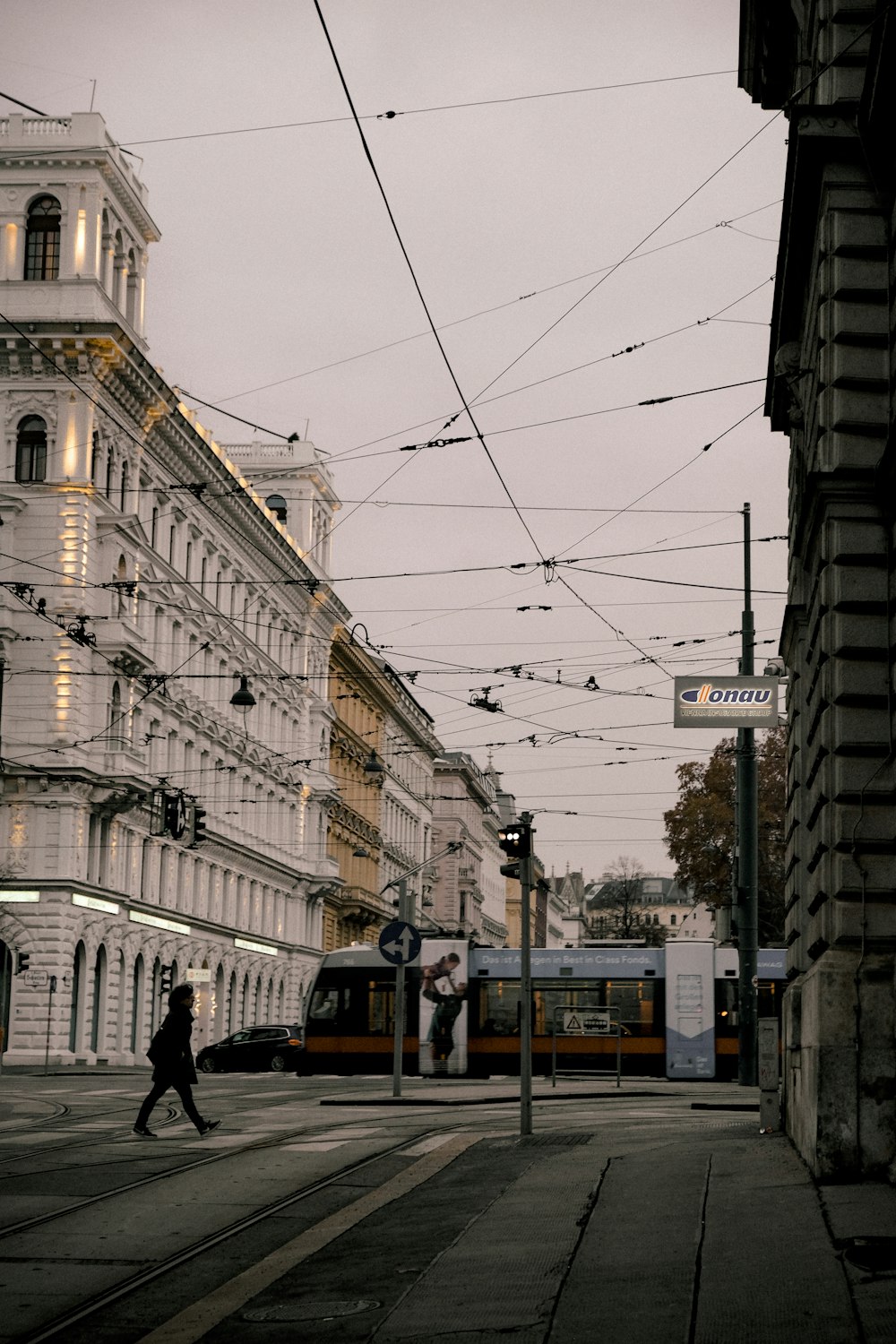 a person walking down a street next to a tall building