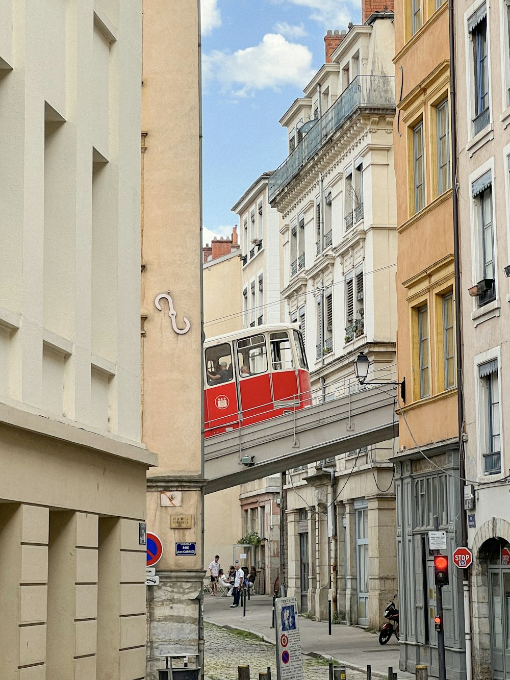 a red tram is going over a bridge in a city