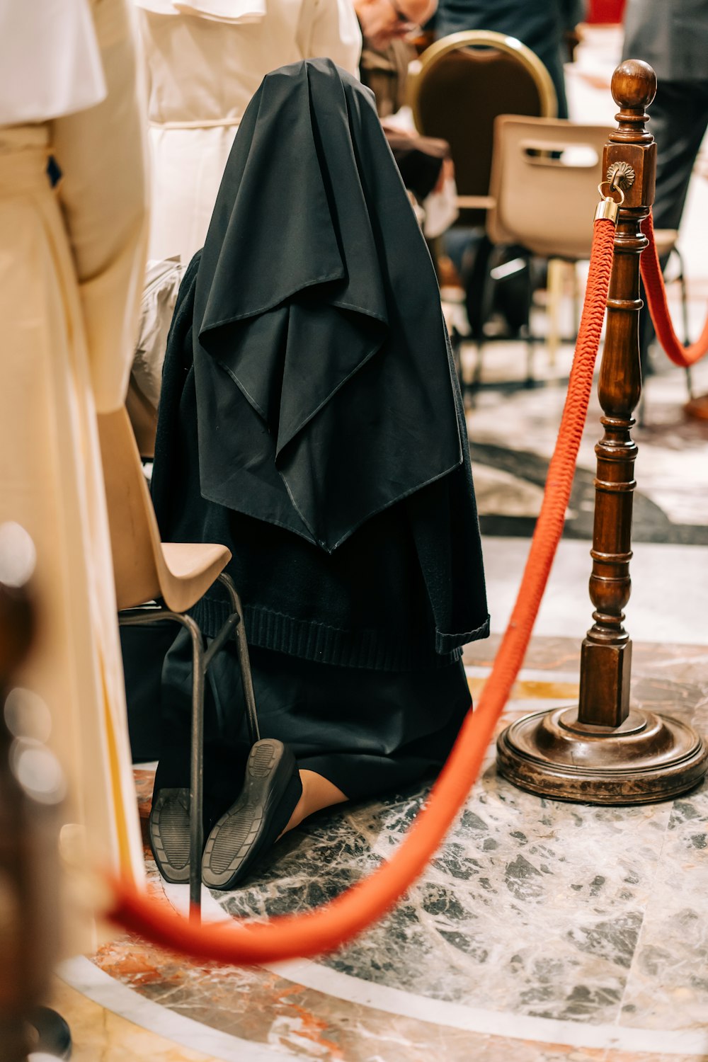 uma mulher em um vestido preto sentado em uma cadeira