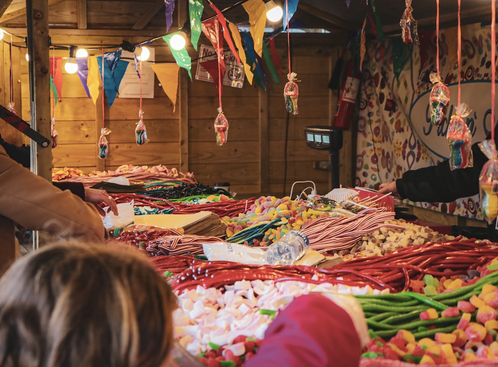 a woman and child looking at candy at a market