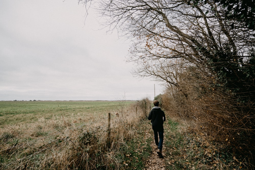 una persona che cammina lungo un sentiero in un campo