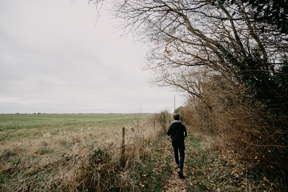 a person walking down a path in a field