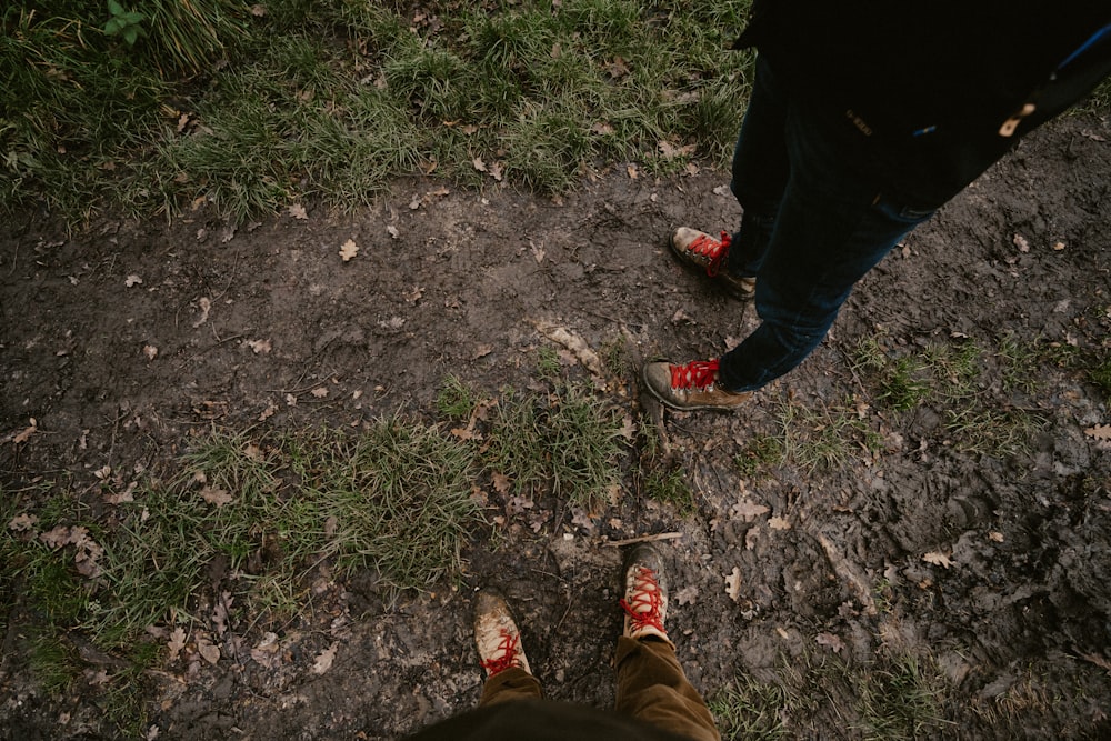 a person with red shoes standing in the grass
