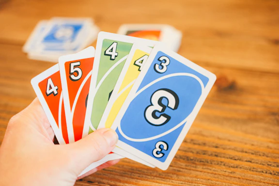 a person holding four cards with numbers on them