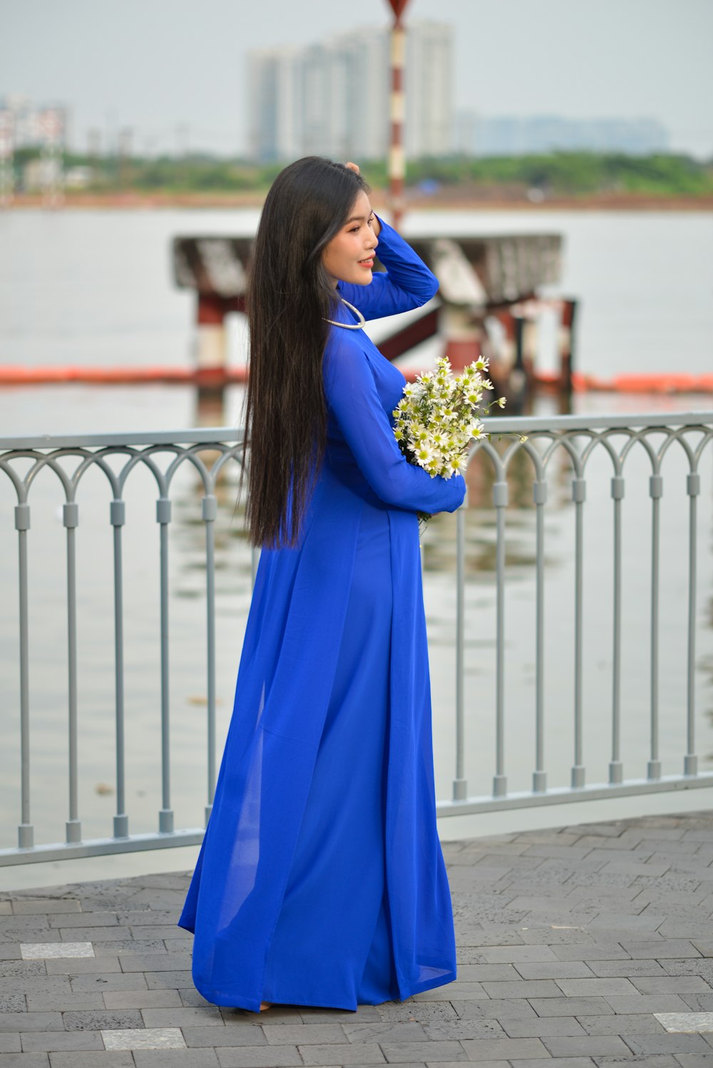 a woman in a blue dress holding a bouquet of flowers