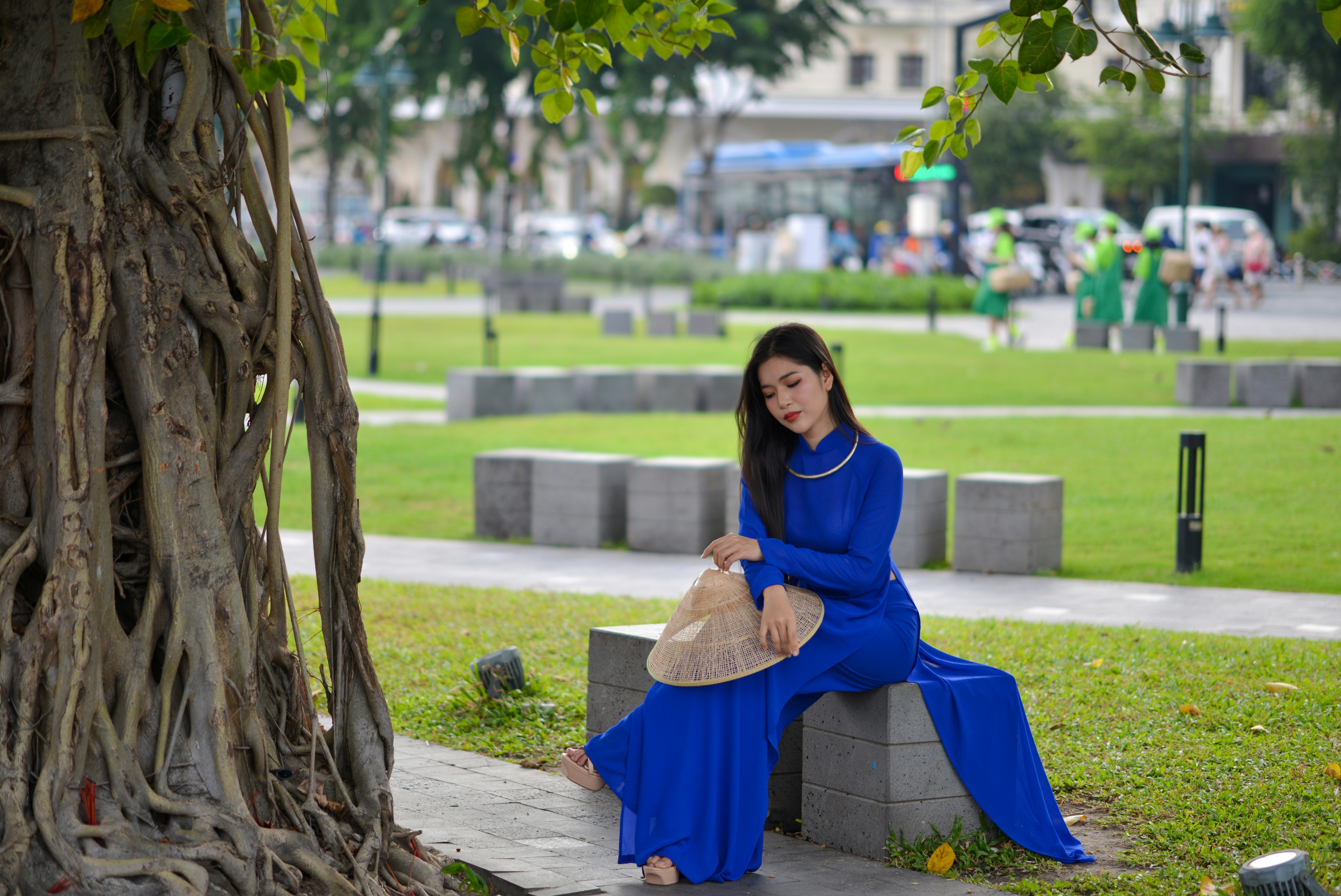 a woman in a blue dress sitting on a bench