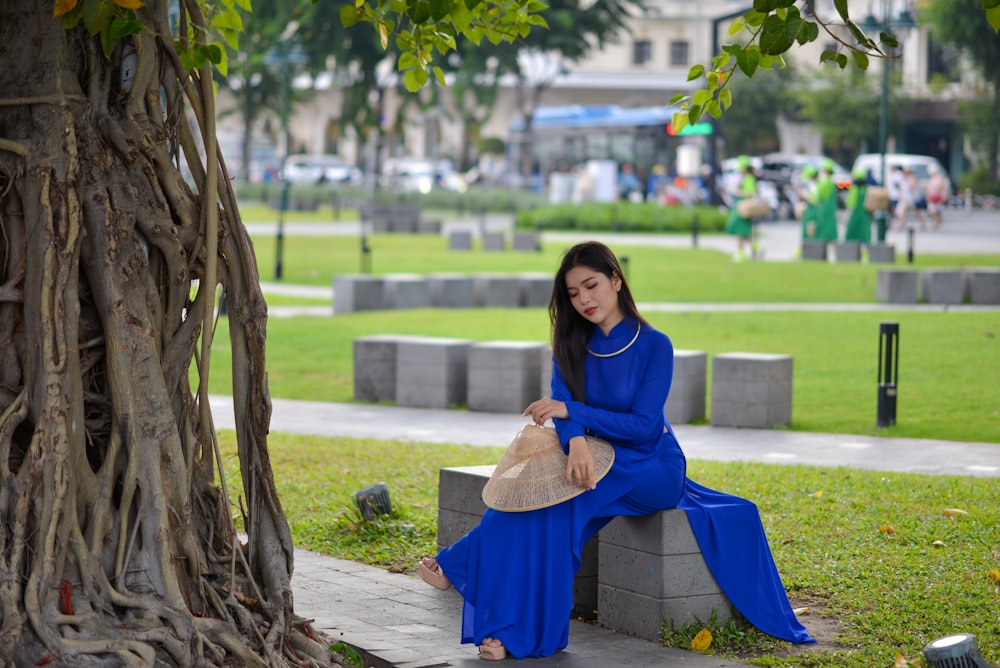 une femme en robe bleue assise sur un banc