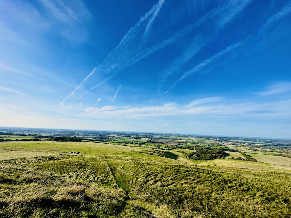 a wide open field with a blue sky in the background