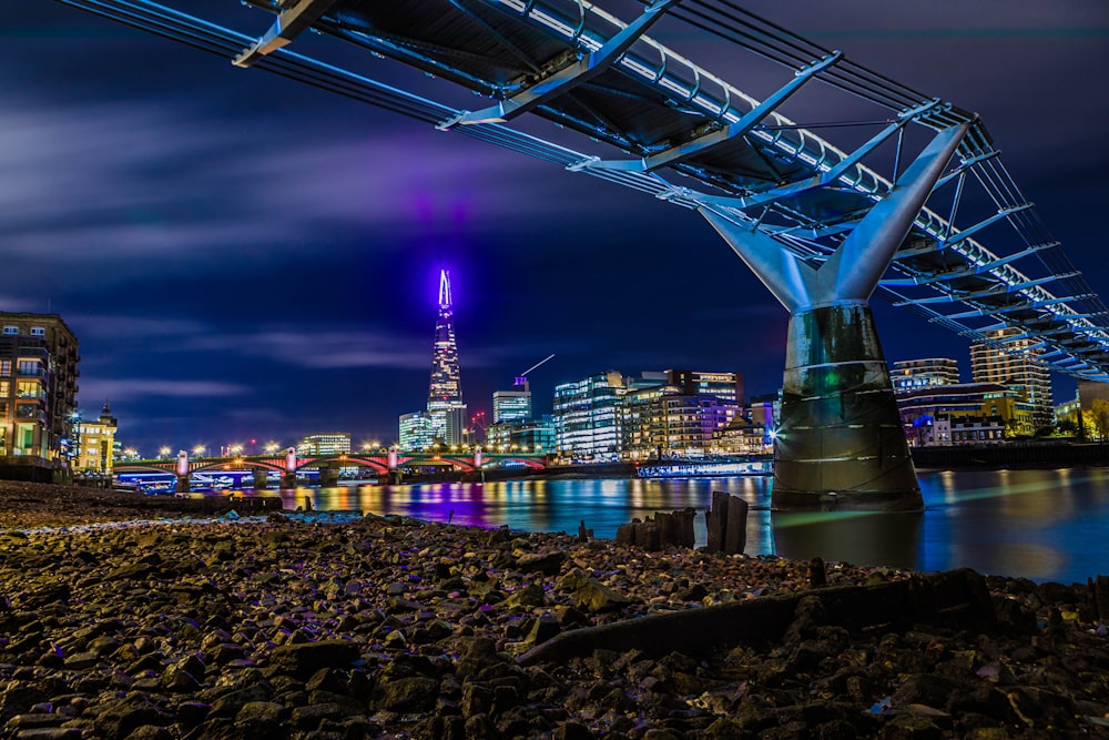 a bridge over a river with a city in the background