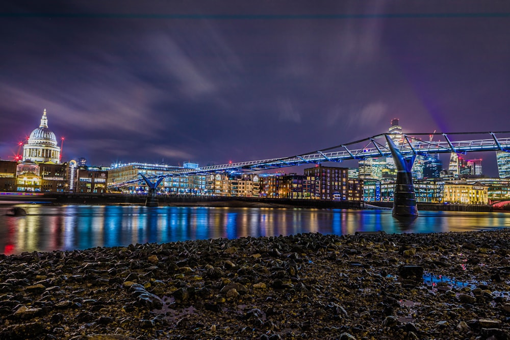 a bridge over a body of water with a city in the background