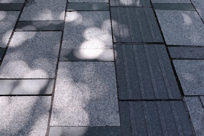 Outdoor flooring paved with beige marble tiles reflecting sunlight