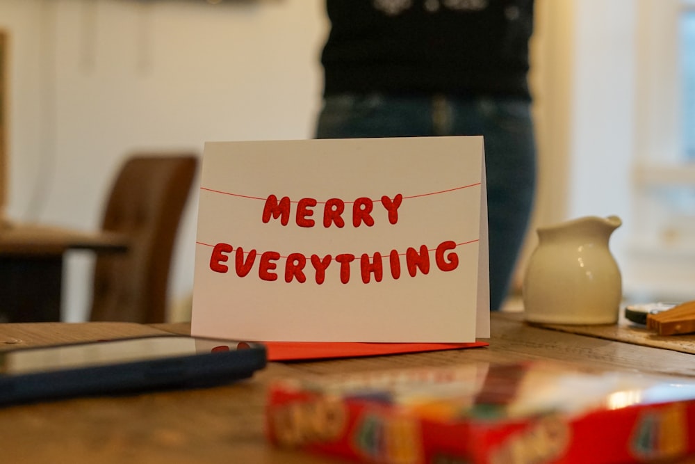 a card that says merry everything sitting on a table