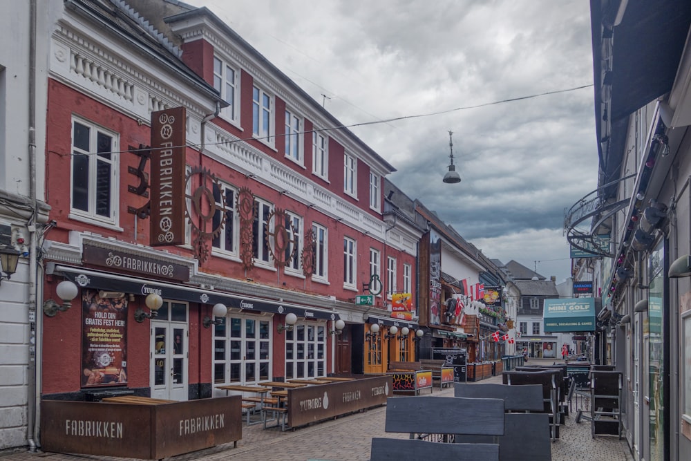 a row of buildings with tables and chairs in front of them