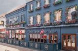 a blue building with many windows and flowers on it