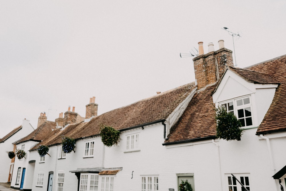 a row of white houses with brown roofs