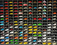 A neatly organized shelf filled with various remote control cars and drones ready for play.