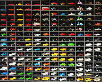 A colorful display of electric toy cars and bikes arranged neatly inside Sri Bhavish Toy House in Bengaluru.