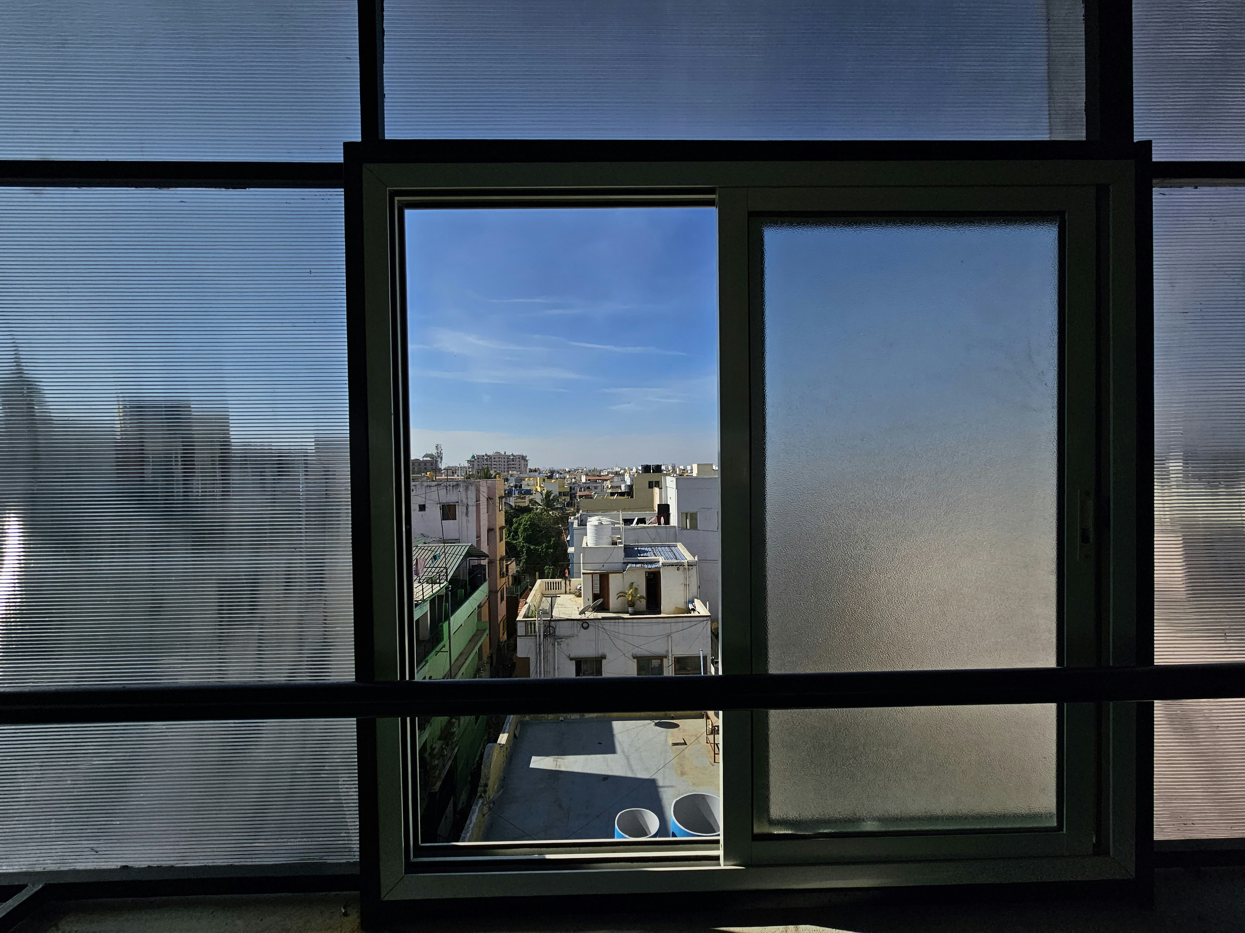 a stylish loft apartment with a large window showing a city view - Downtown apartment living