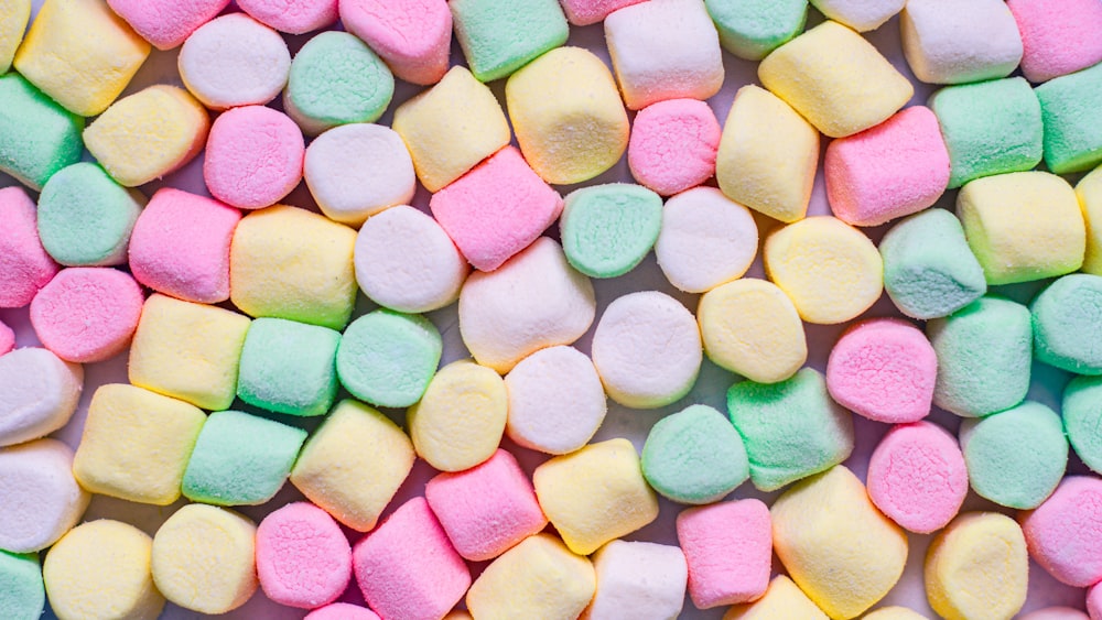 a pile of colorful marshmallows on a white surface