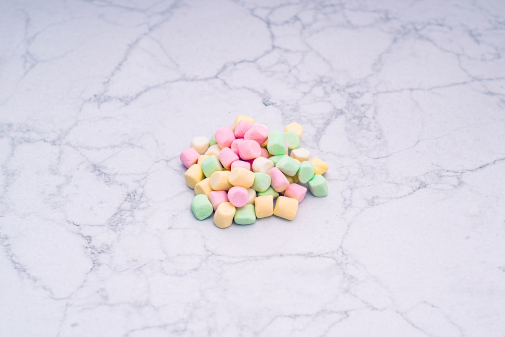 a pile of colorful marshmallows on a marble surface