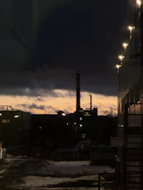 A panoramic view of an industrial energy facility at sunset, highlighting operational activity.