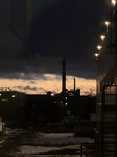 Industrial engineering team inspecting equipment at an oil and gas facility during sunset.