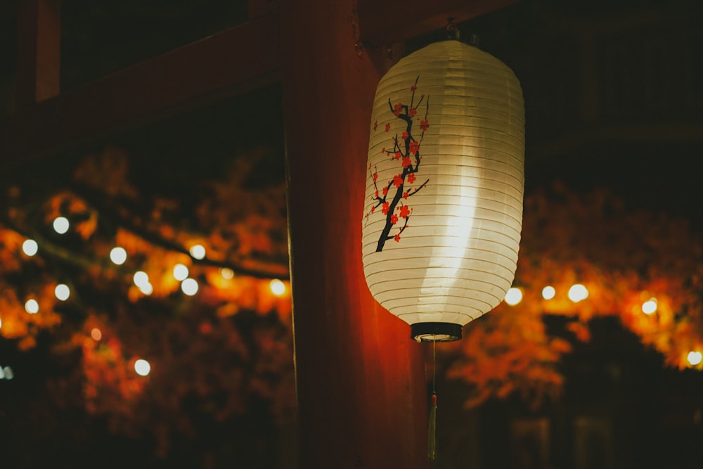 a lantern hanging from a pole with lights in the background