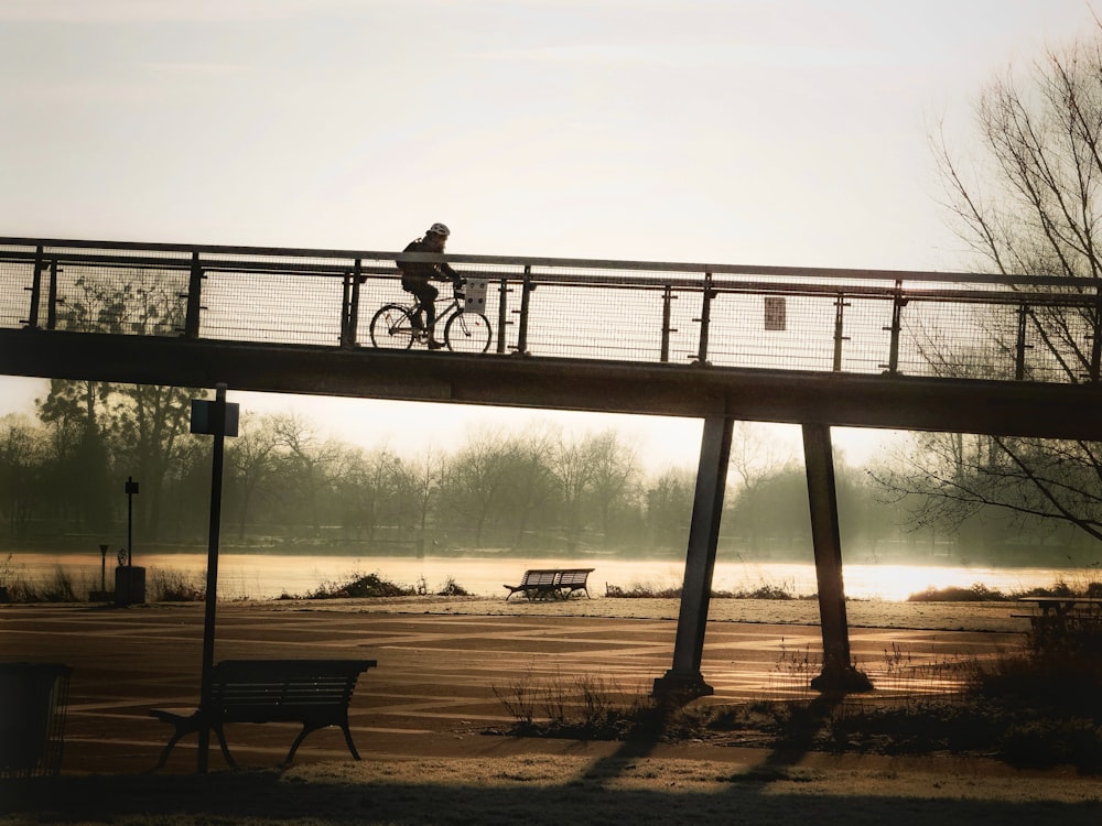 eine Person, die mit dem Fahrrad über eine Brücke fährt