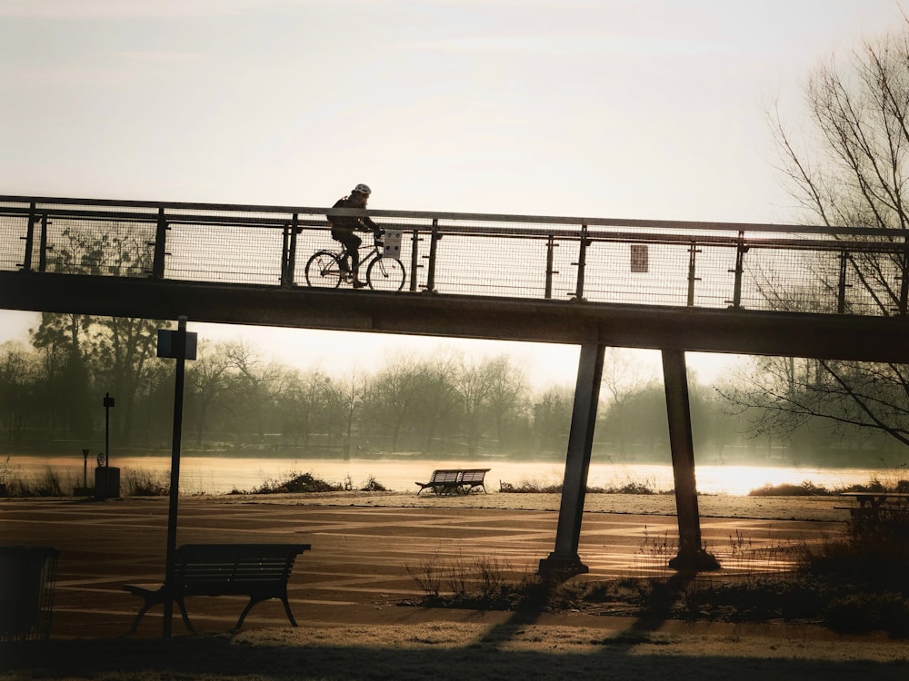a person riding a bike across a bridge