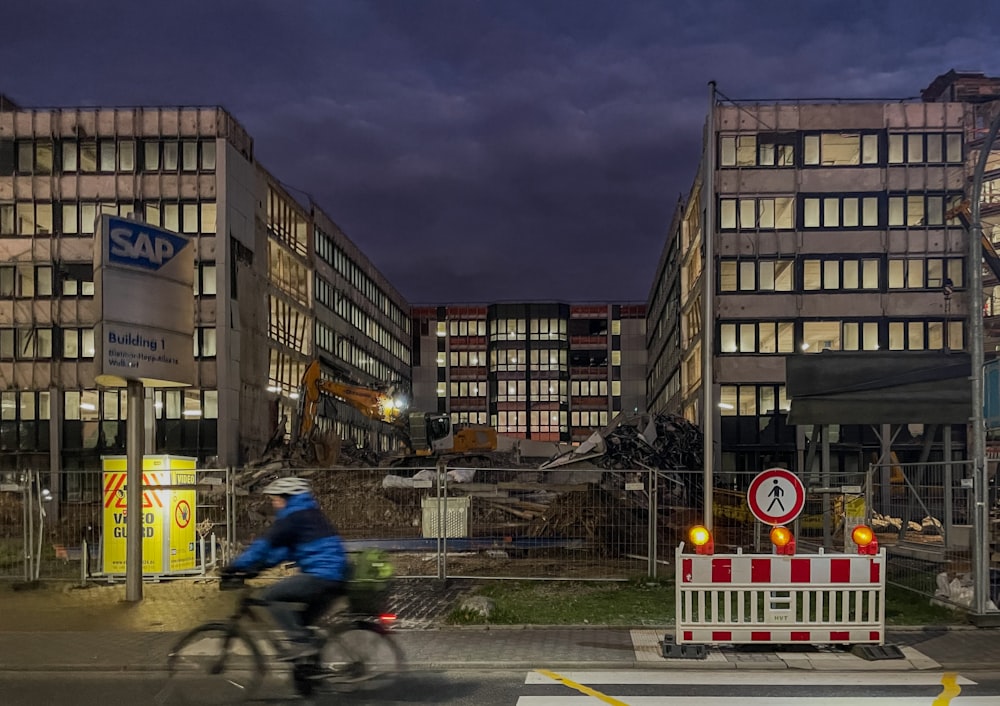 a man riding a bike down a street next to tall buildings