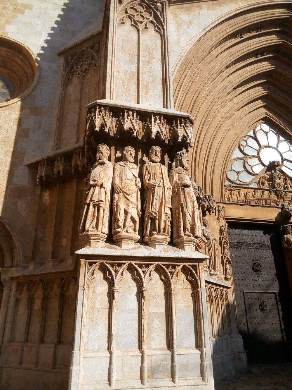 eine Statue vor einer Kathedrale mit einer Uhr