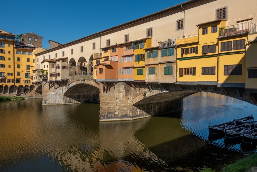 a bridge over a body of water with buildings in the background