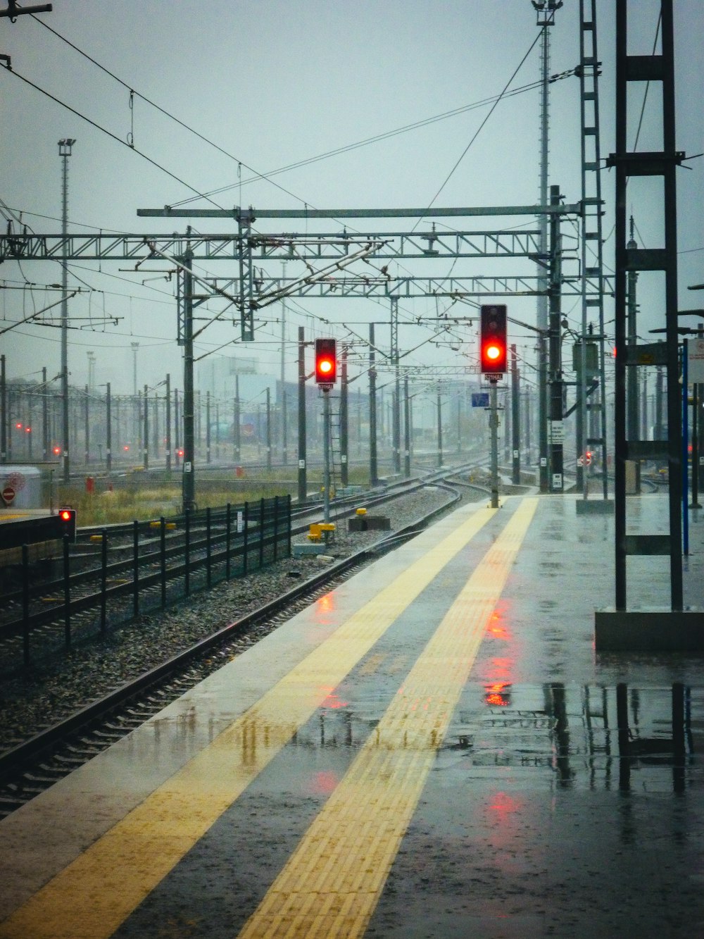 a train station with a red light on a rainy day