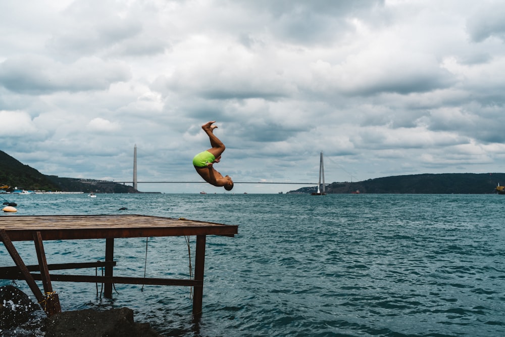 a person jumping off a dock into the water
