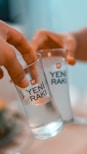 two people holding glasses with water in them