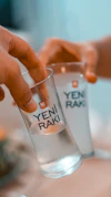 two people holding glasses with water in them